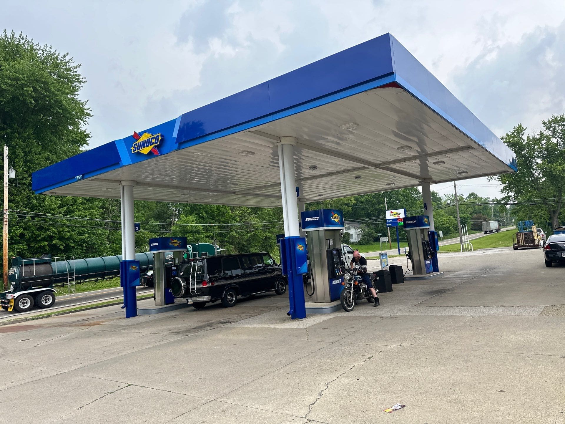 Sunoco gas station with fuel truck van, motorcyclist parked