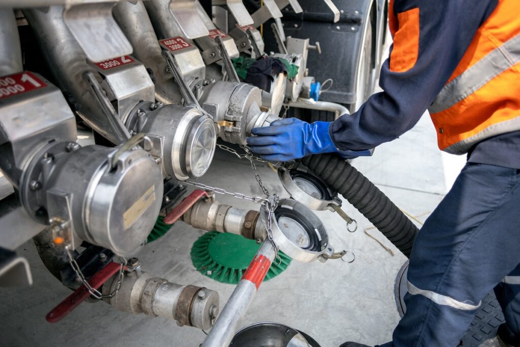 tube connected to fuel tank with man holding in place