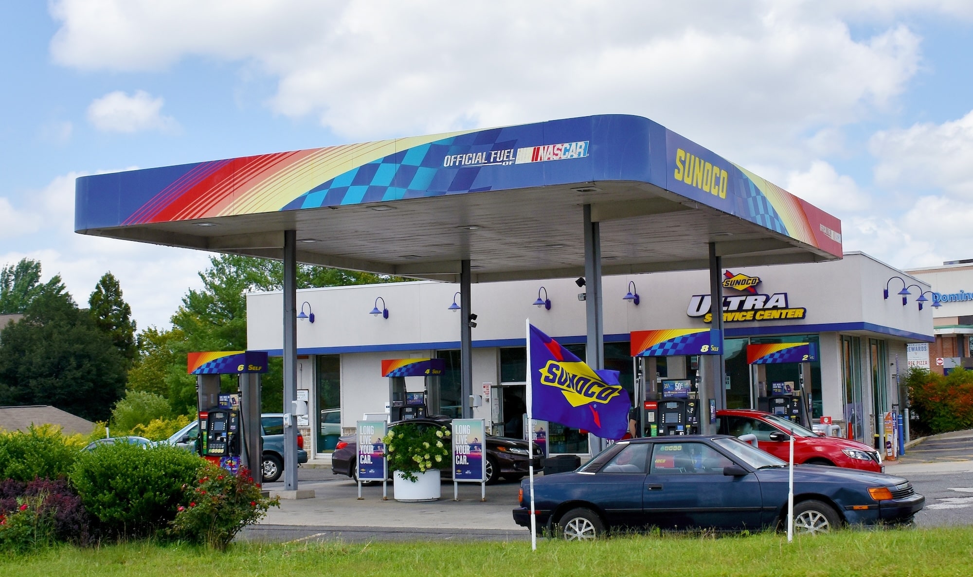 Sunoco gas station with flowers and gas parked getting gas
