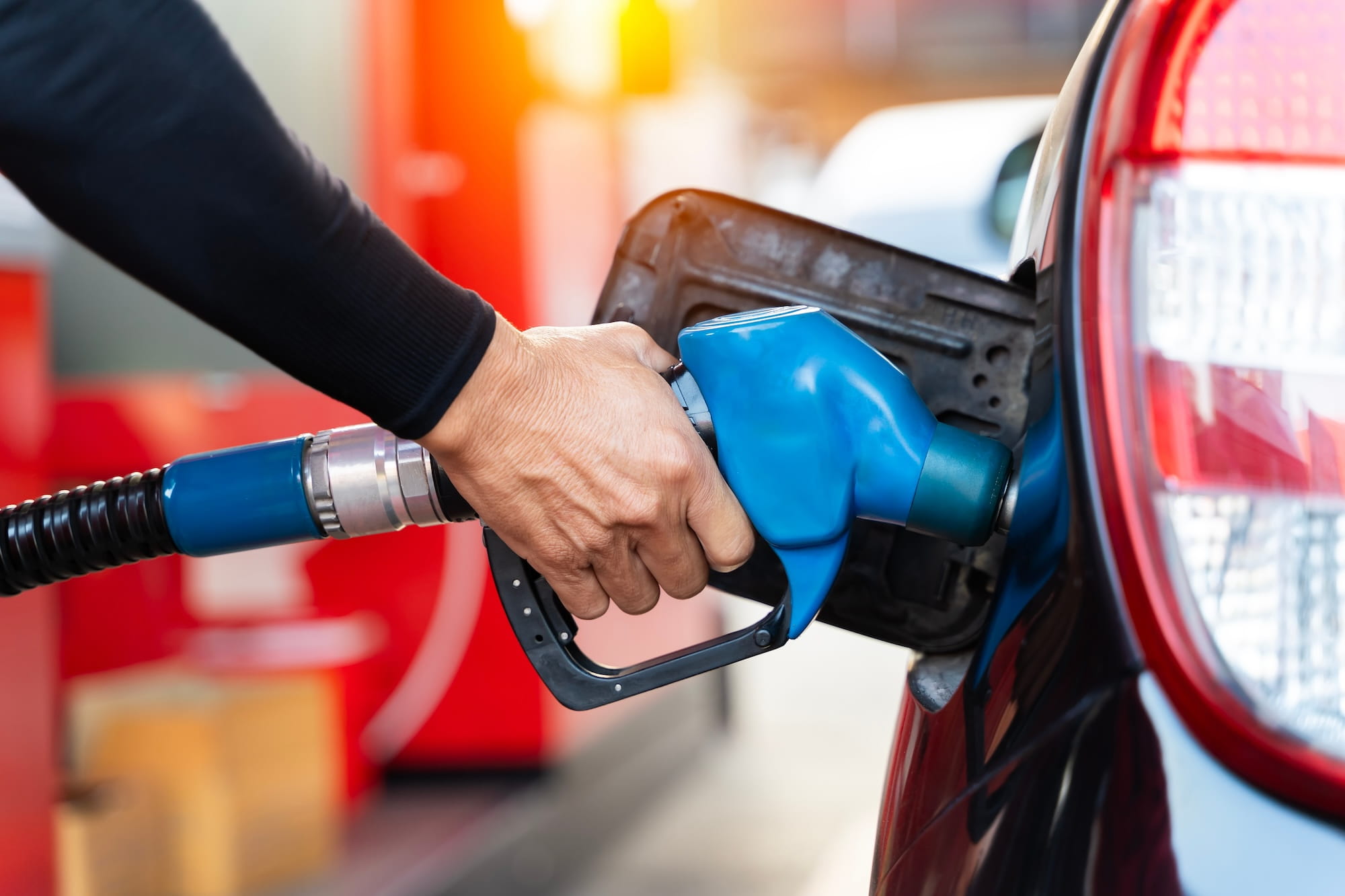 Man holding blue gas pump in the car